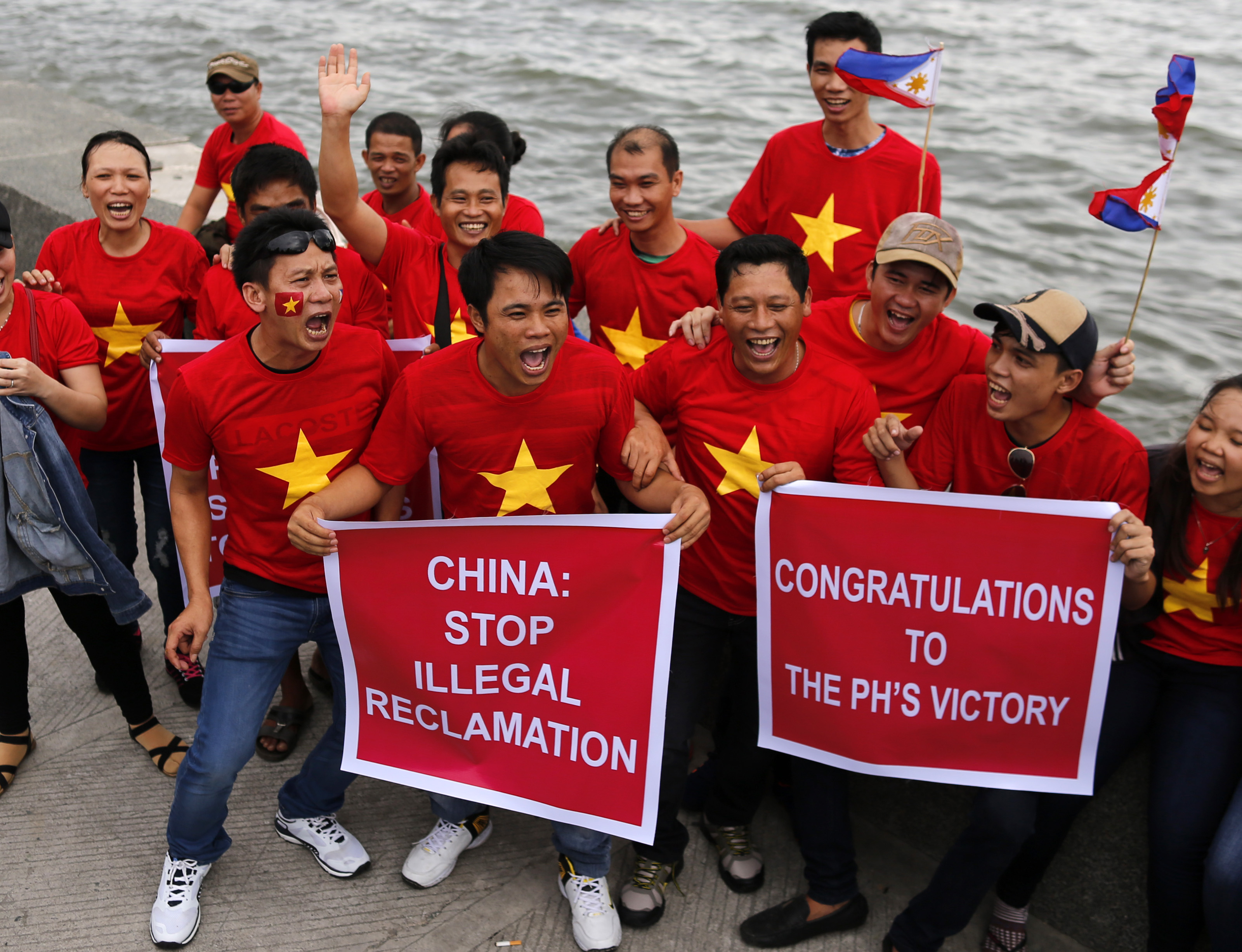 GLOBAL COMMUNITY. Vietnamese hold placards as they join a victory rally along Roxas Boulevard in Manila on July 12. Photo by Francis Malasig/EPA 