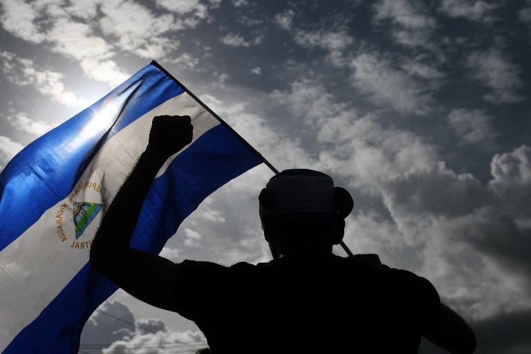 IN PROTEST. In this file photo, an anti-government demonstrator waves a flag while taking part in a protest in Managua, Nicaragua on June 17, 2018. File photo by Marvin Recinos/AFP  