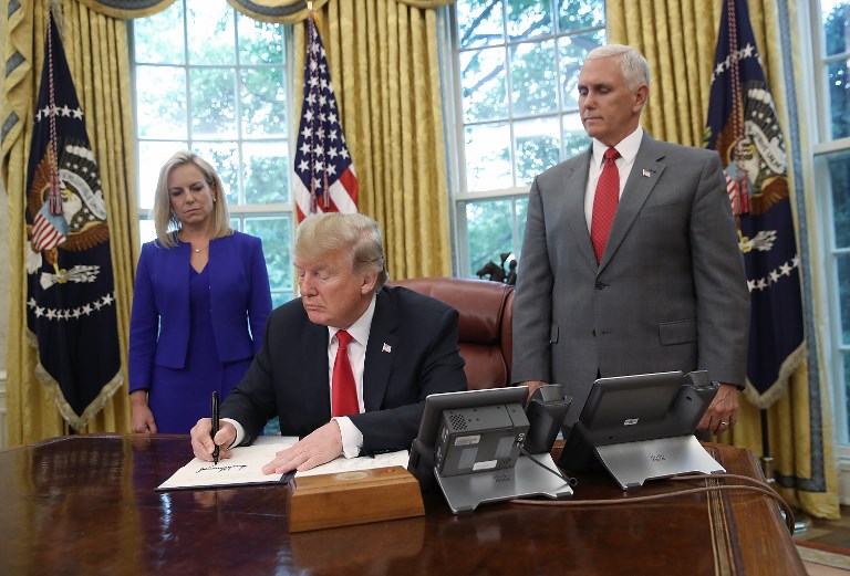 SIGNED. US President Donald Trump signs an executive order that will end the practice of separating family members who are apprehended while illegally entering the United States on June 20, 2018 in Washington, DC. Photo by Win McNamee/Getty Images/AFP  