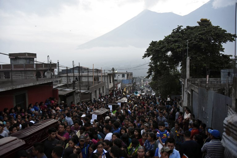 DEATH TOLL RISES. Residents carry the coffins of seven people who died following the eruption of the Fuego volcano, along the streets of Alotenango municipality, Sacatepequez, about 65 km southwest of Guatemala City, on June 4, 2018. Photo by Johan Ordonez/AFP 