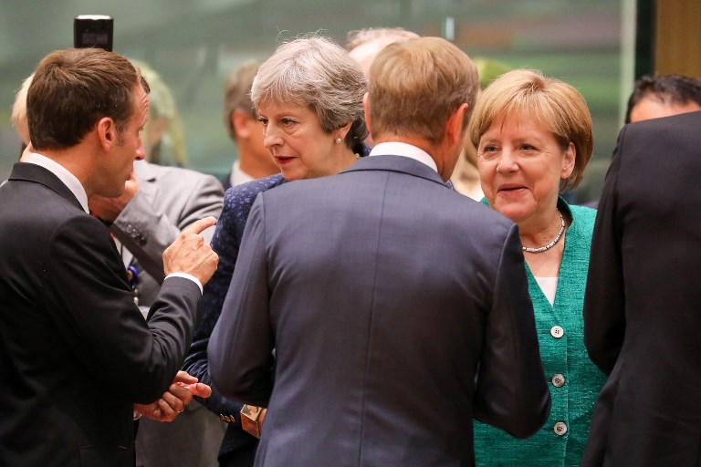 EU SUMMIT. France's President Emmanuel Macron (L) speaks with Britain's Prime Minister Theresa May (2ndL) as European Council President Donald Tusk (2ndR) speaks with Germany's Chancellor Angela Merkel during a European Union leaders' summit focused on migration, Brexit and eurozone reforms on June 28, 2018 at the Europa building in Brussels. Photo by Ludovic Marin/AFP 
