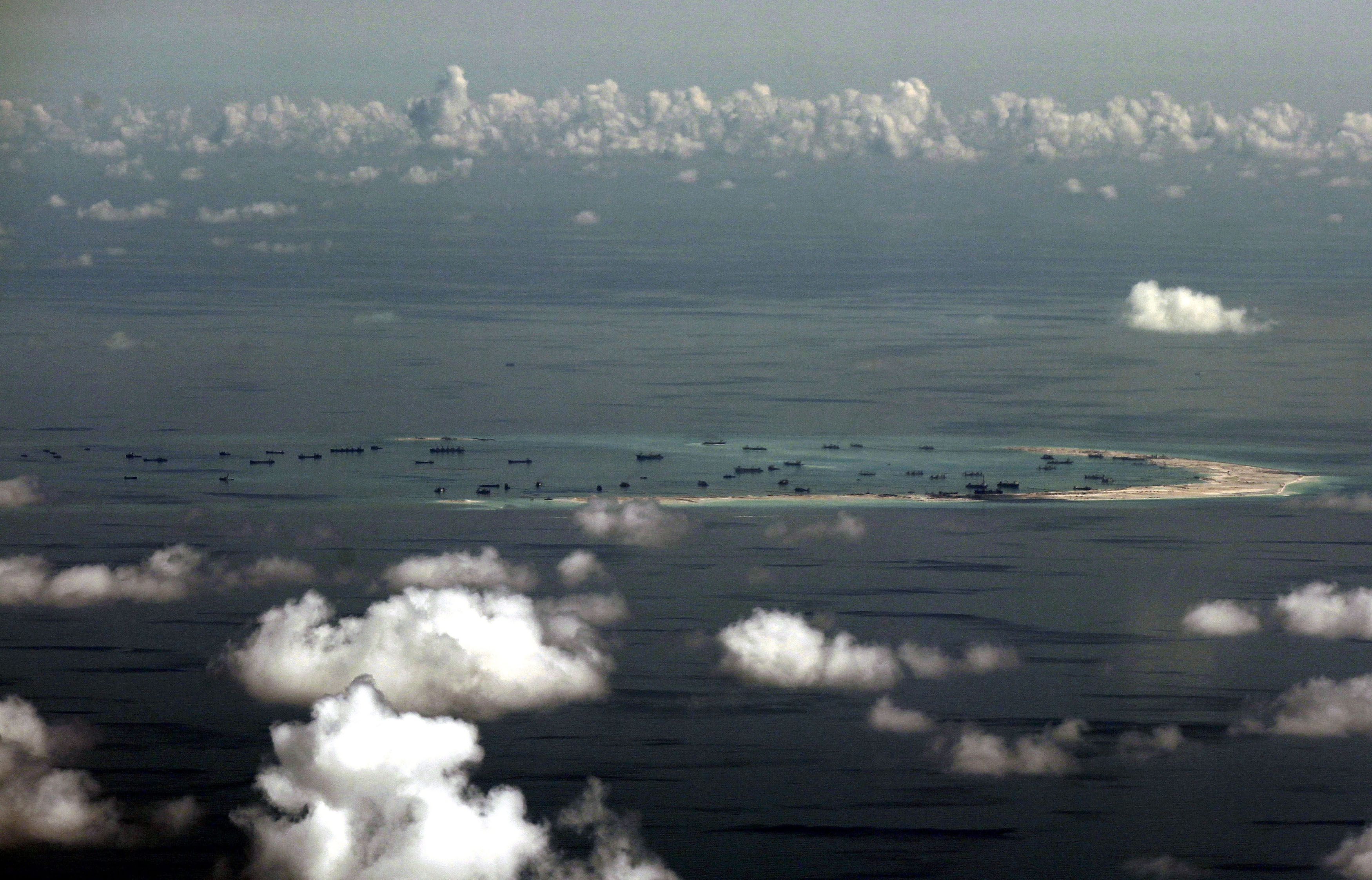 ARTIFICIAL ISLAND. An areal photo taken though a glass window inside a military plane of the alleged on-going reclamation by China into mischief reef in the Spratly group of islands in the South China Sea, west of Palawan, Philippines, May 11, 2015. Ritchie Tongo/EPA 