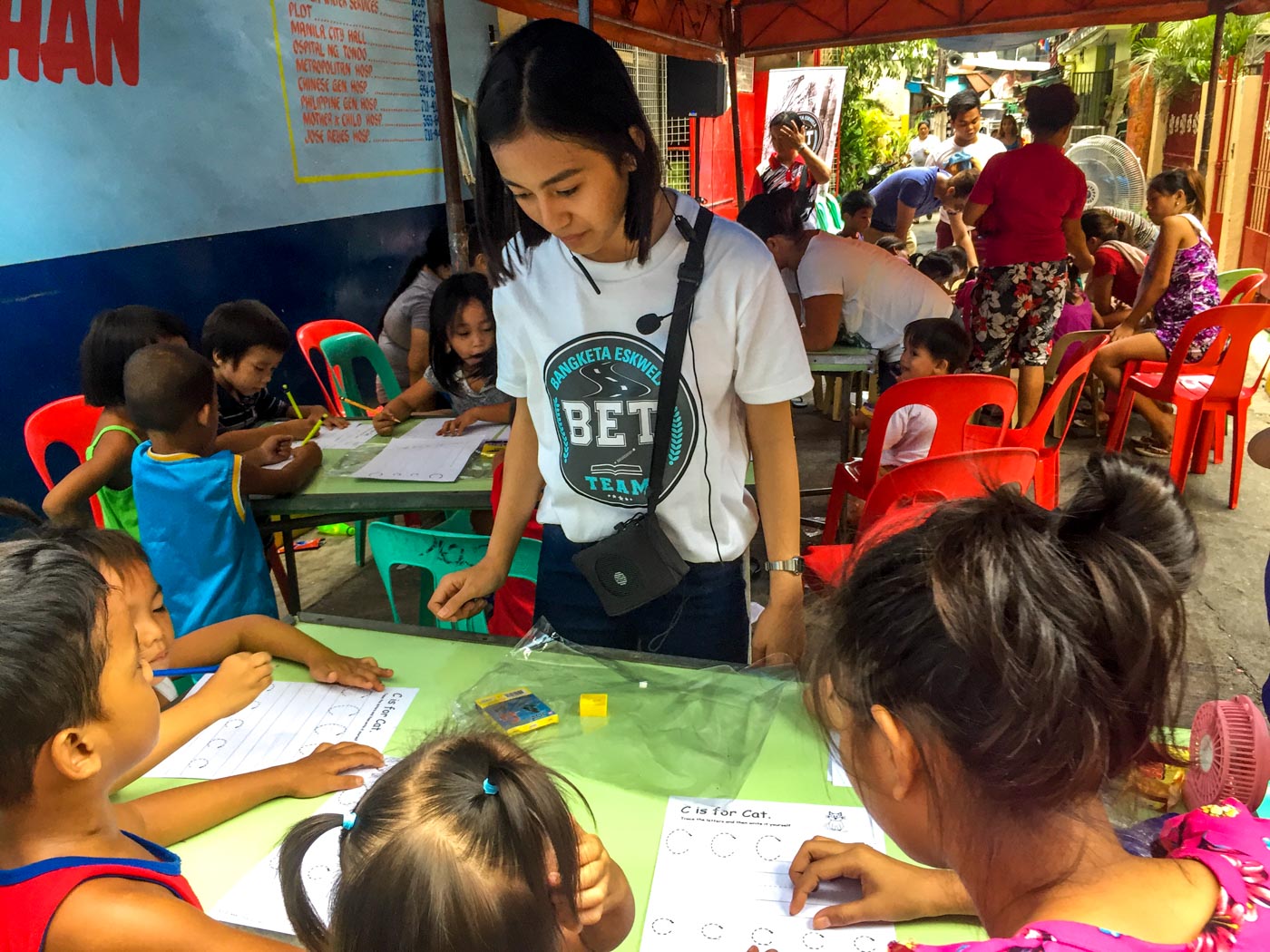 THE TUTOR. Dara Mae Tuazon oversees the students’ worksheets and gives them words of encouragement to do their best. Photo by Luisa Jocson