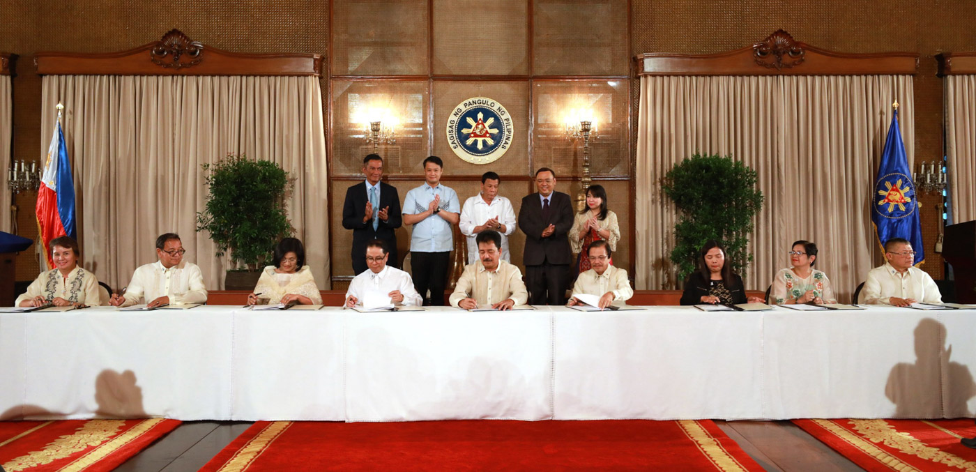 FREE EDUCATION. President Rodrigo Duterte and lawmakers witness the signing of an agreement for the implementation of the free tertiary education law. Malacañang photo 