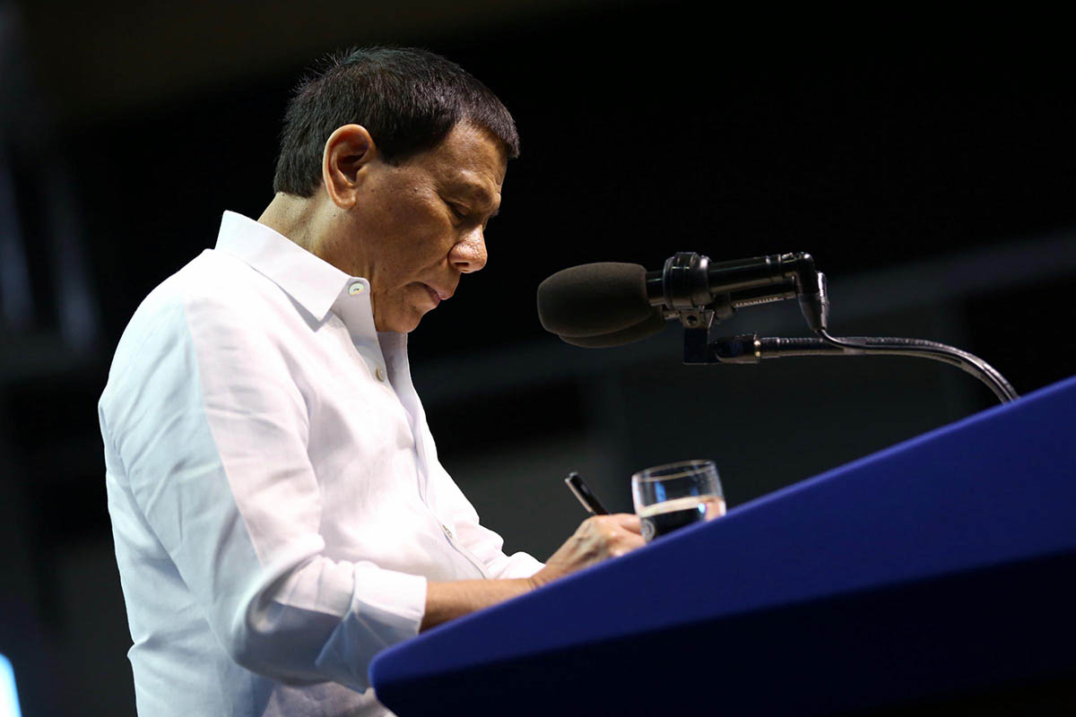 EXECUTIVE ORDER. President Rodrigo Duterte signs an executive order on illegal contractualization during the 116th Labor Day Celebration at the IEC Convention Center in Cebu City on May 1, 2018. Malacañang photo 