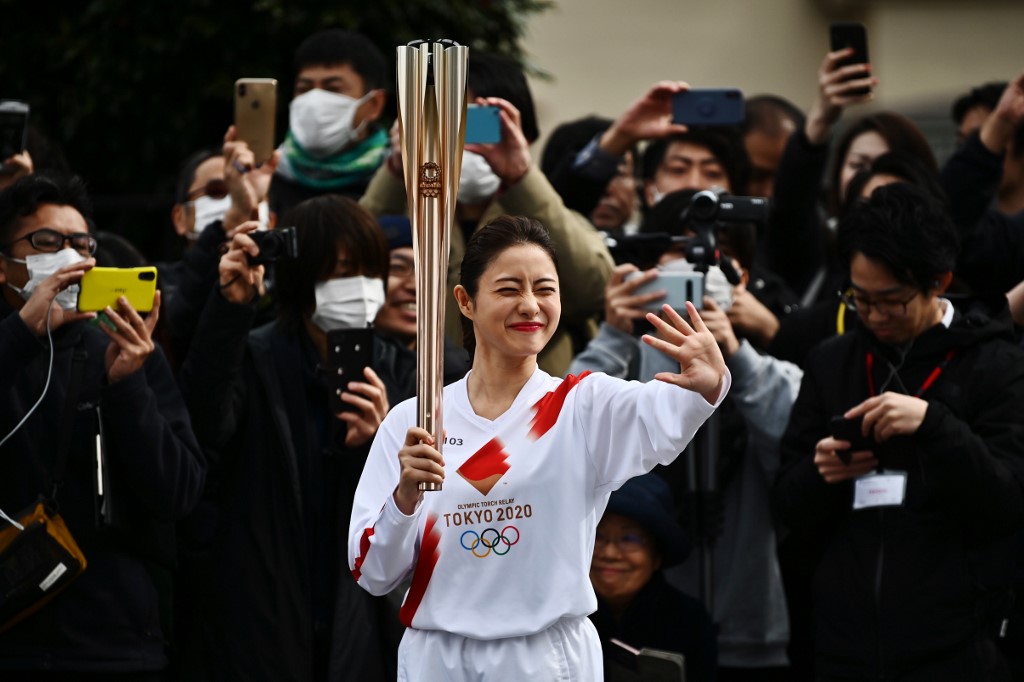 TORCHBEARER. Japanese actress Satomi Ishihara waves during a rehearsal of the Tokyo 2020 Olympics torch relay. Photo by Charly Triballeau/AFP
 
