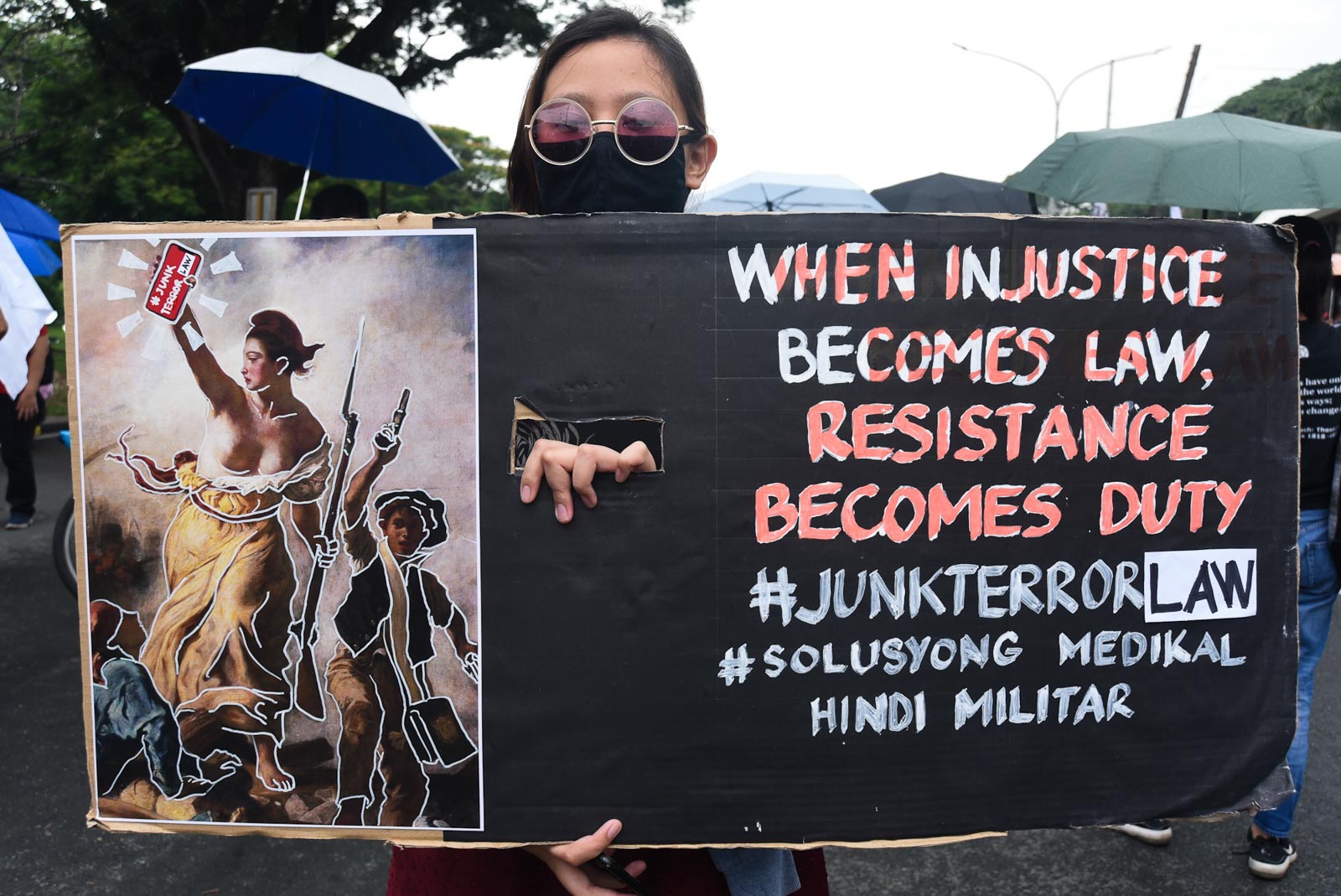 RESIST. A protester shows a placard expressing opposition against the signed anti-terror law. Photo by Angie de Silva/Rappler 