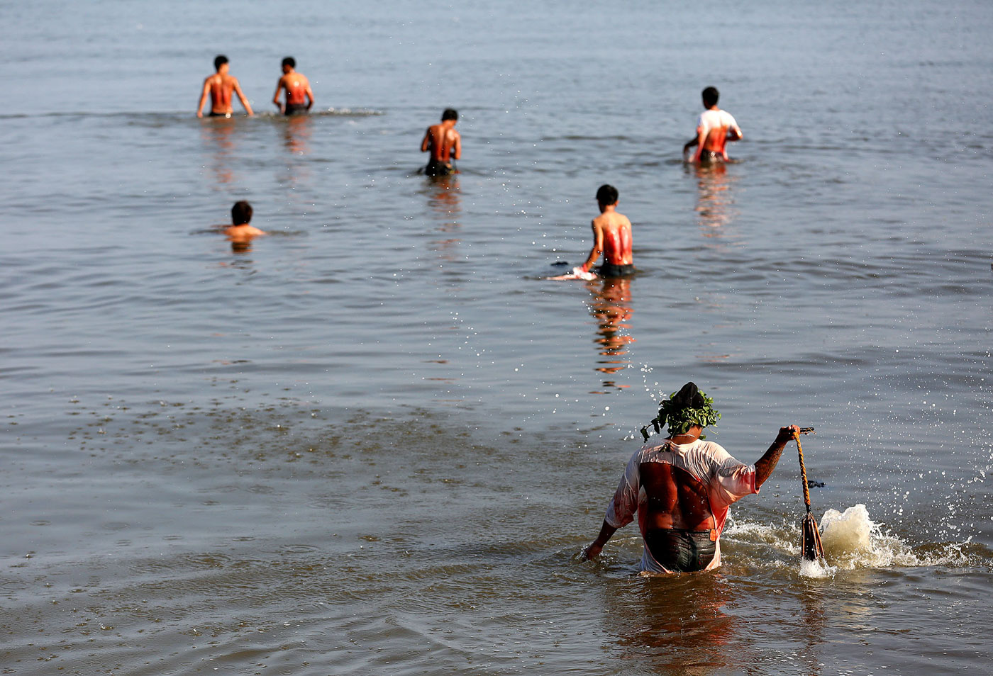 SWIM. After the procession, penitents take a dip in Manila Bay to wash the blood and clean their bodies. Photo by Inoue Jaena/Rappler   