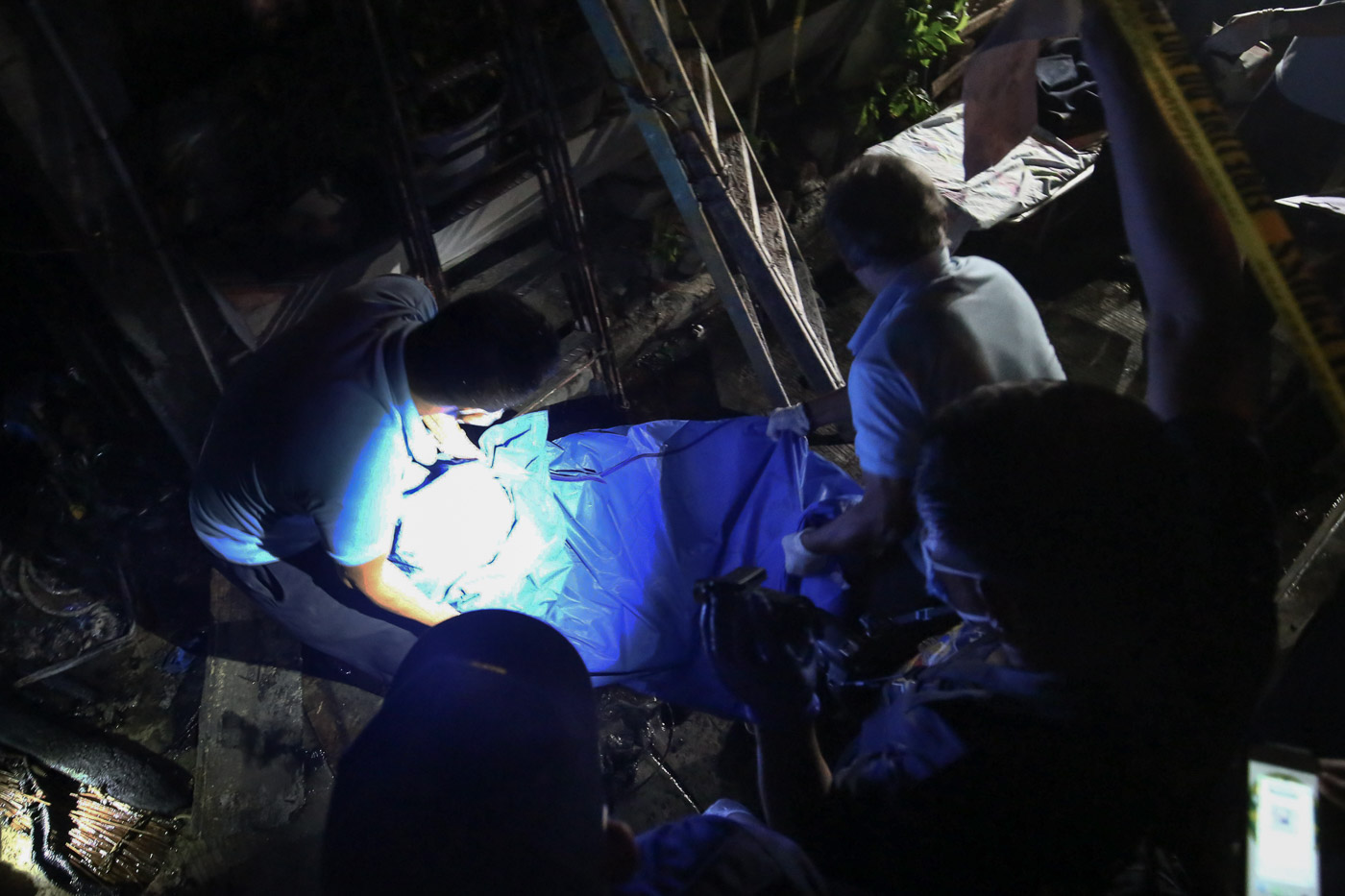CHARRED. Crime scene investigators and funeral parlor personnel recover the charred bodies from a house along Almazor street in Pasay City. All photos by Ben Nabong/Rappler  