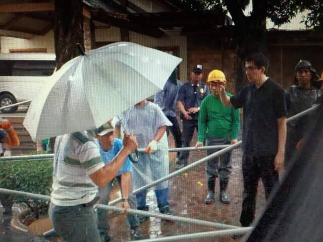 BARRICADED. Angel Manalo confronts workers building the fences inside the Tandang Sora compound on December 15. File photo   