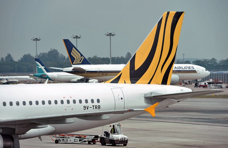 This photograph taken on November 12, 2015 shows Singapore Airline and its subsidiary Silk Air and Tigerair sitting on the tarmac at Changi International airport in Singapore. Roslan Rahman/AFP 