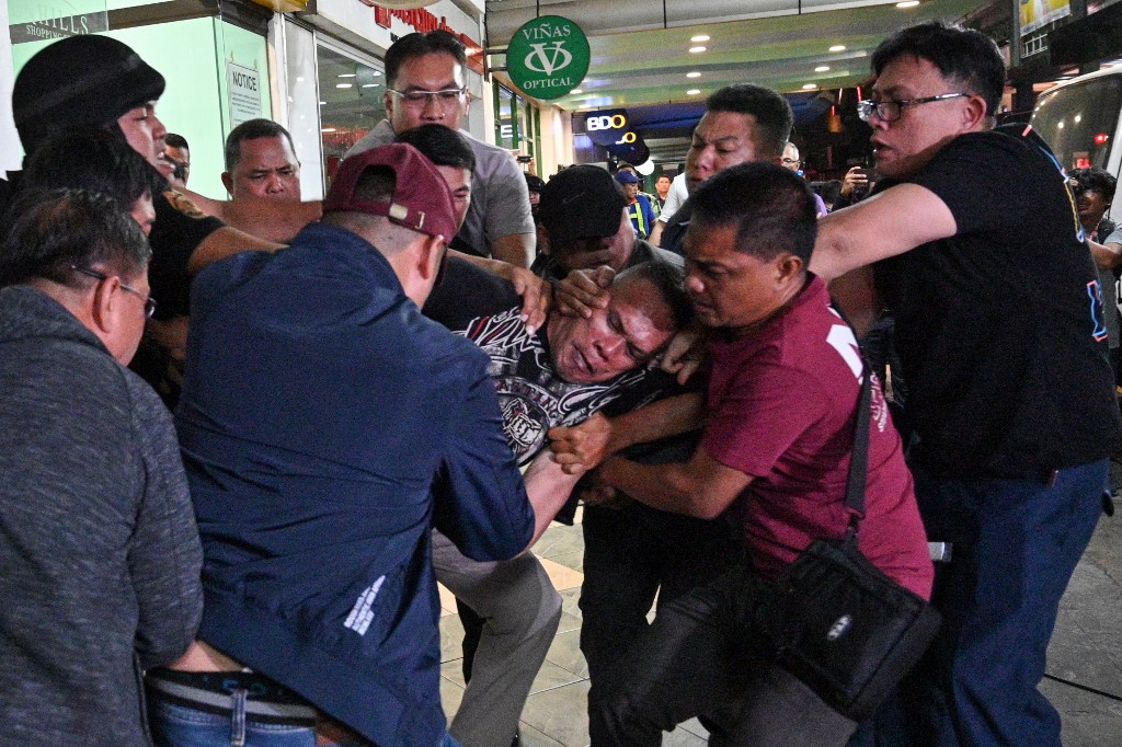 ARRESTED. Policemen subdue hostage taker Alchie Paray (center) after he surrenders outside a mall in Greenhills, San Juan, Metro Manila on March 2, 2020. AFP photo