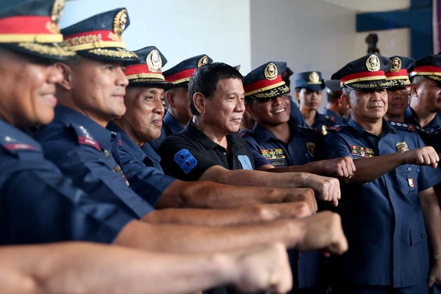 DUTERTE'S GIFTS? President Rodrigo Duterte does the clenched fist gesture with officers of Philippine National Police Regional Office-9 at Camp Abendan in Zamboanga City on October 10. File photo by Rey Baniquet/Presidential Photo 