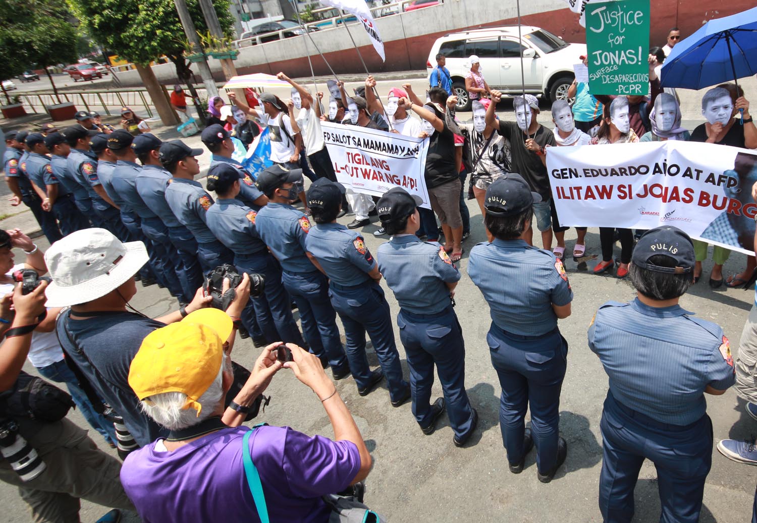 PEACEFUL PROTEST. Cops guard the gate of the military headquarters Camp Aguinaldo from the protesters. Photo by Darren Langit/Rappler  