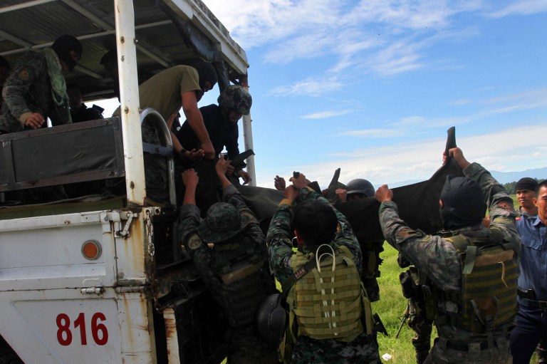 JUSTICE SOUGHT. In this file photo, Philippine police commandos carry body bags containing the remains of their comrades killed in a clash with Muslim rebels in Mamasapano. File photo by AFP  