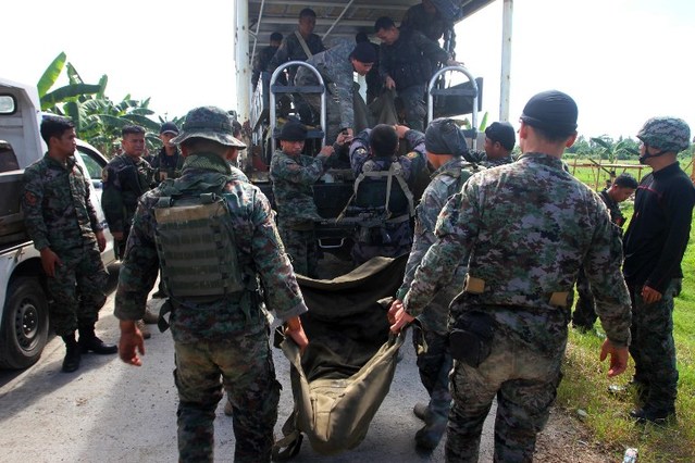 THE FALLEN. Philippine police commandos load body bags containing the remains of their comrades killed in a clash with Muslim rebels, onto a truck in the town of Mamasapano on January 26, 2015. File photo by Mark Navales/AFP  