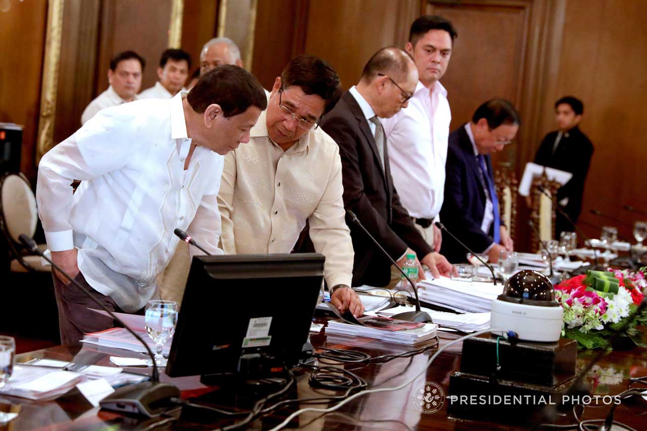 SECURITY CONCERNS. President Rodrigo Duterte is shown a pile of documents by National Security Adviser Hermogenes Esperon Jr during a National Security Council (NSC) Executive Committee meeting. Malacañang file photo 