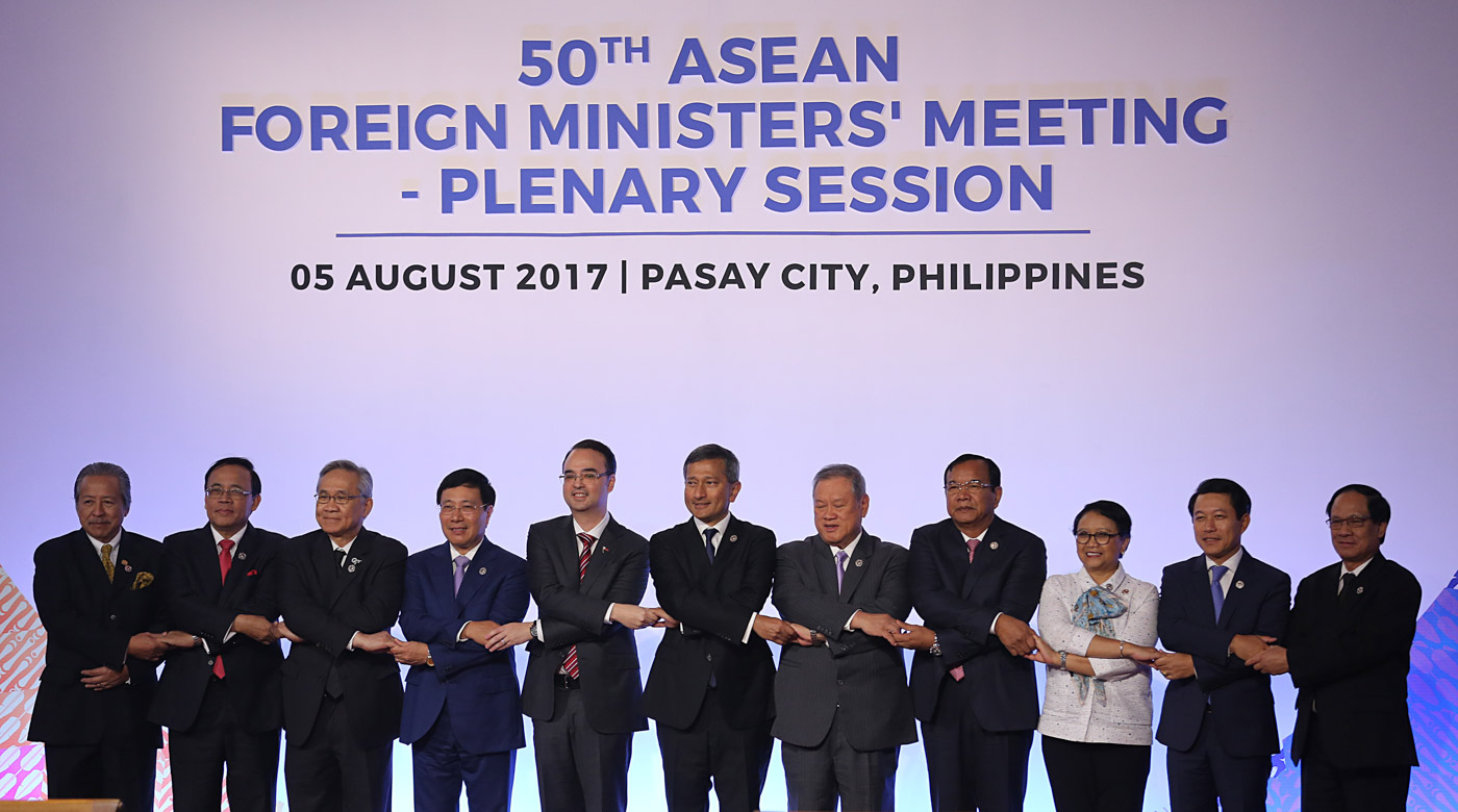 ASEAN foreign ministers join hands for a family photo during the 50th Association of Southeast Asian Nations (ASEAN) Foreign Ministers' Meeting Plenary Session in Manila. ASEAN pool photo 