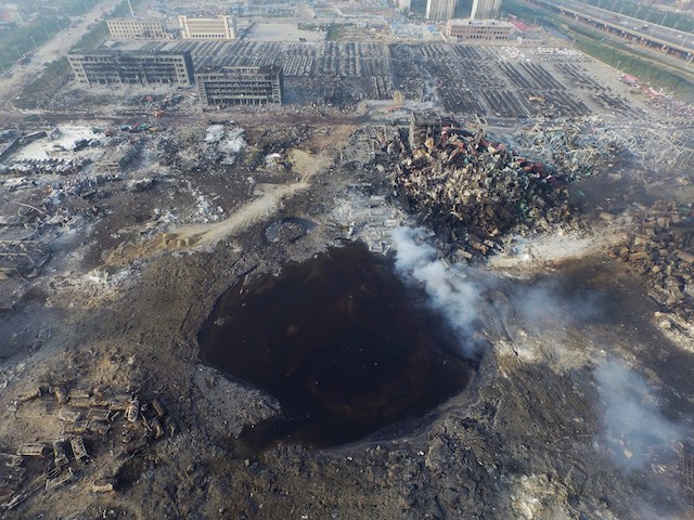 GROUND ZERO. An aerial view of a large hole in the ground in the aftermath of a huge explosion that rocked the port city of Tianjin, China, August 15, 2015. Stringer/EPA 