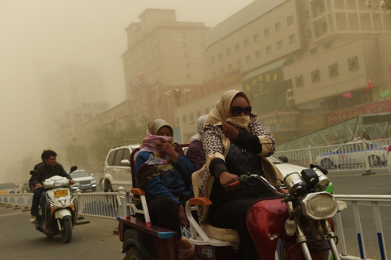 UN REVIEW. This photo taken on April 16, 2015 shows Uighurs riding through a sand storm, in China's western Xinjiang region. File photo by Greg Baker/AFP 