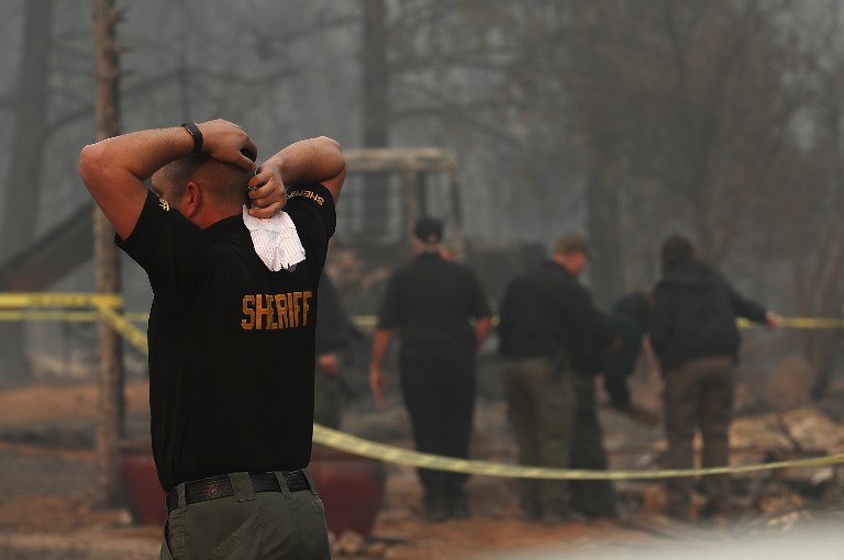 BLAZE RUINS. A Butte County sheriff deputy stands by at a destroyed home where a deceased victim of the Camp Fire on November 10, 2018 in Paradise, California. Photo by James Sullivan/Getty Images North America/AFP 