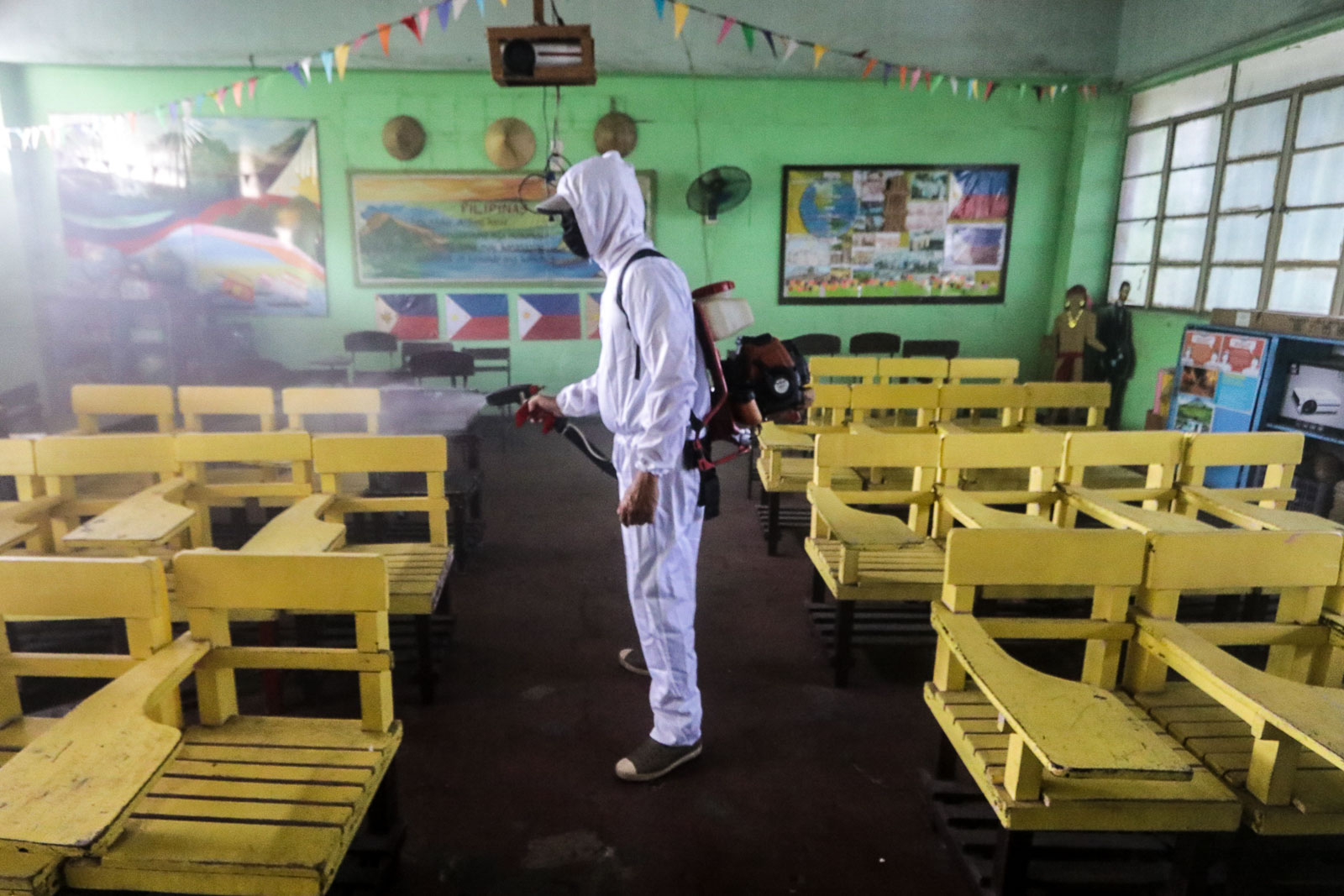 CLASSES IN A PANDEMIC. A Manila Health Department staff disinfects a classroom of M. Hizon Elementary School on June 1, 2020. File photo by KD Madrilejos/Rappler  