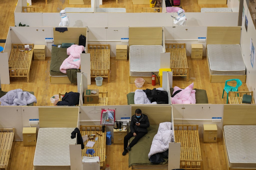 PATIENTS. This photo taken on March 5, 2020 shows empty beds as a patient rests at a temporary hospital set up for COVID-19 coronavirus patients in a sports stadium in Wuhan, in China's central Hubei province.  Photo by AFP.  