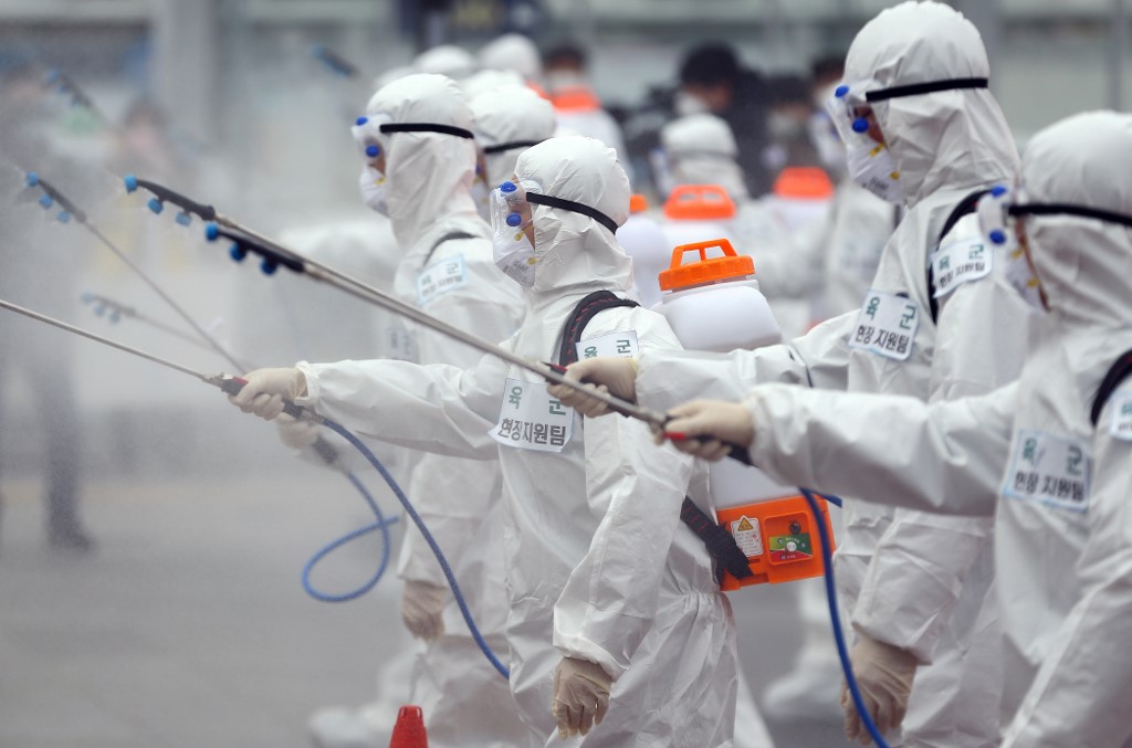 COMBATING CORONAVIRUS. South Korean soldiers wearing protective gear spray disinfectant at Dongdaegu railway station in Daegu City on February 29, 2020. Photo by Yonhap/AFP 