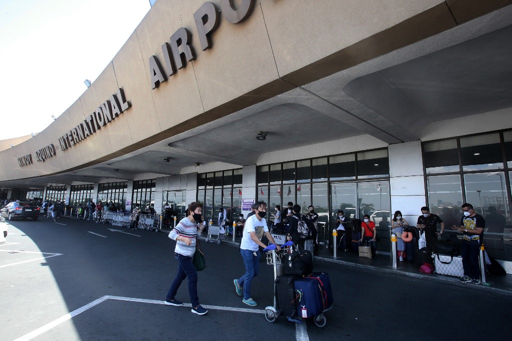 NAIA. Passengers queue outside as they wait for their flights at the Ninoy Aquino International Airport on March 19, 2020. AFP file photo 