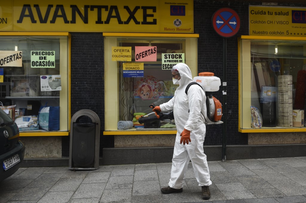 LOCKDOWN. A man dressed in protective gear carries out disinfection works in a street in Vigo, northwestern Spain, on March 31, 2020 during a national lockdown to prevent the spread of the novel coronavirus. Photo by Miguel Riopa/AFP 