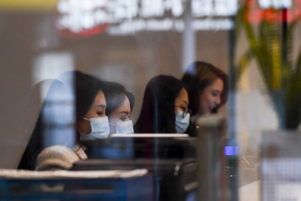 VIRUS PROTECTION. Tellers wearing face masks work at a currency exchange store in Melbourne, Australia, on March 5, 2020. Photo by William West/AFP 