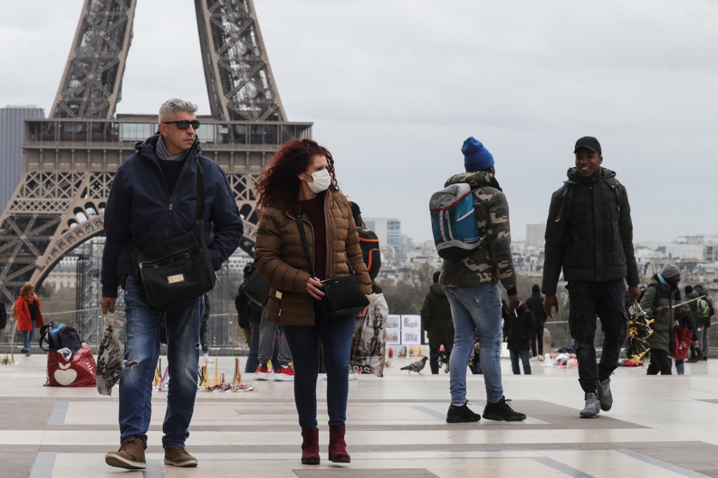 TOURISM. People walk in front of the Eiffel Tower in Paris, France, on March 12, 2020. File photo by Ludovic Marin/AFP 