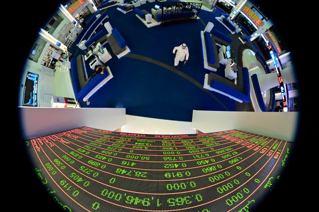 STOCKS. A picture taken with a fisheye lens shows traders walking by beneath a stock display board at the Dubai Stock Exchange in the United Arab Emirates on March 8, 2020. Photo by Giuseppe Cacace/AFP 