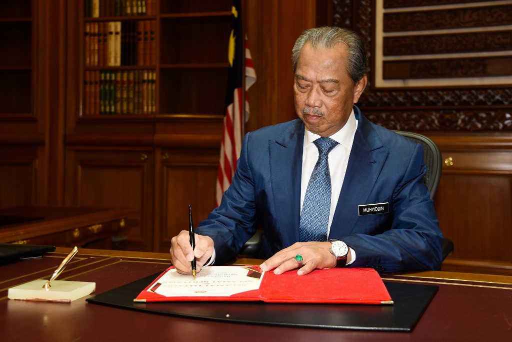 FIRST DAY. This handout photo taken and released on March 2, 2020, by Malaysia's Department of Information shows the country's new prime minister, Muhyiddin Yassin, signing a document on his first day at the Prime Minister's Office in Putrajaya. Photo by Wazari Wazir/Malaysia's Department of Information/AFP 