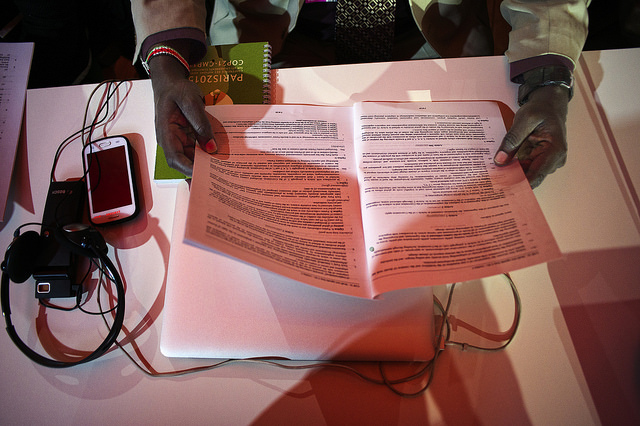 DEAL – OR NO DEAL? The draft text of the Paris agreement is shown being read by a participant at the Comité de Paris meeting during the COP21 climate change conference in Le Bourget, France, December 9, 2015. Photo by Benjamin Géminel/COP21 