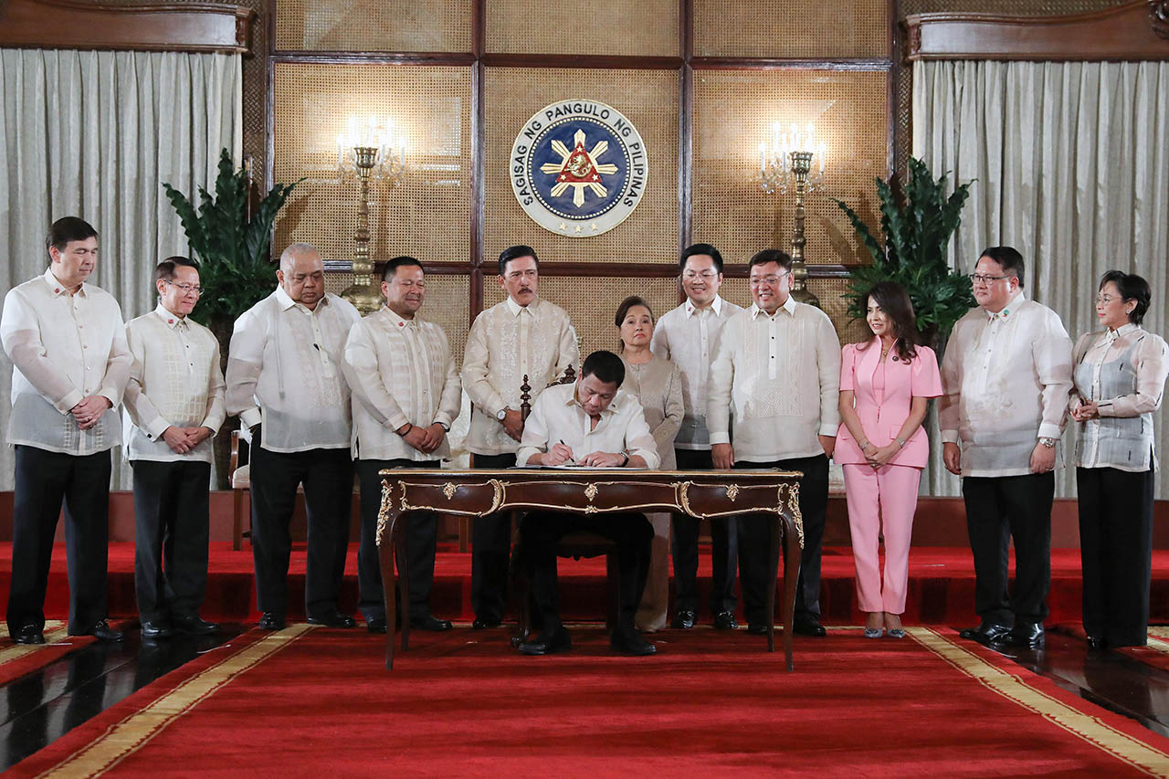 President Rodrigo Roa Duterte leads the ceremonial signing of the Universal Health Care Act, with congressional leaders and some lawmakers who spearheaded the bill. Malacañang photo
   
