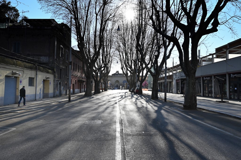 NEW NORMAL. A man walks along a deserted Via Galvani in the Testaccio district of Rome on March 20, 2020 during the country's lockdown aimed at stopping the spread of the COVID-19 (new coronavirus) pandemic. Photo by Alberto Pizzoli/AFP  