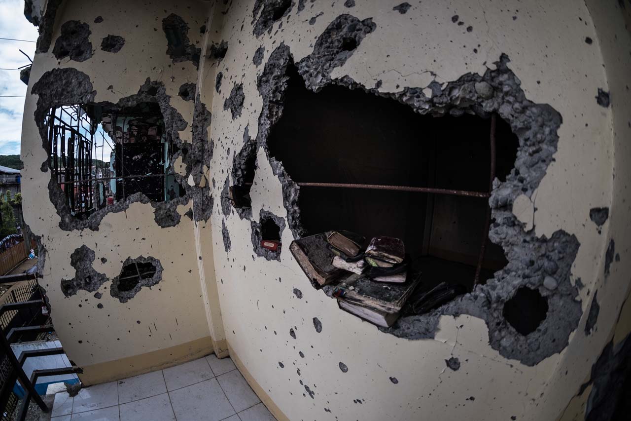 SHELLED. Bullet-riddled second floor of the building where Isnilion Hapilon was renting a unit. On the holes are recovered copies of the Quran. Bobby Lagsa/Rappler
   