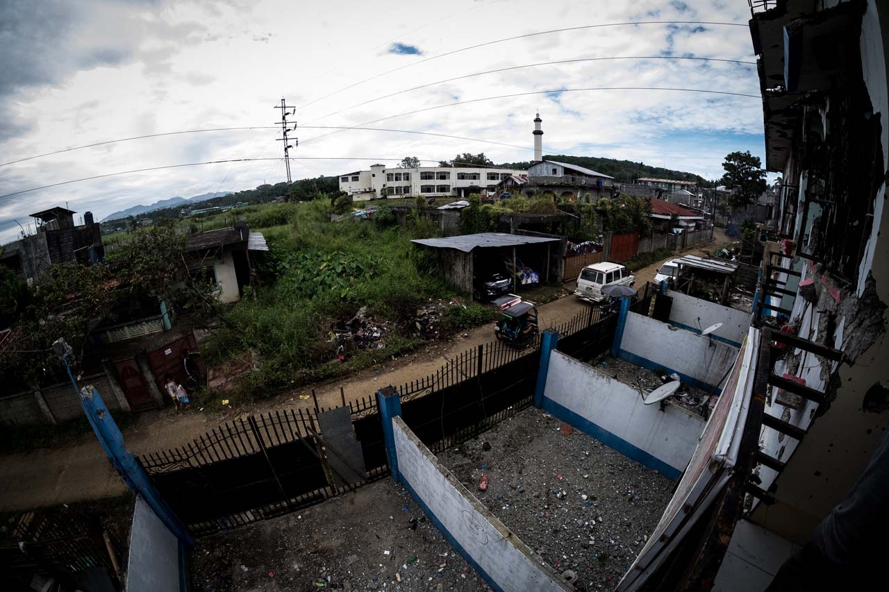 ROOM WITH A VIEW. The view from one of the rooms of the rented apartment of Isnilon Hapilon, with the gate blasted open by special forces to gain entry into the house (the one with a sheet of tin attached) . Bobby Lagsa/Rappler   