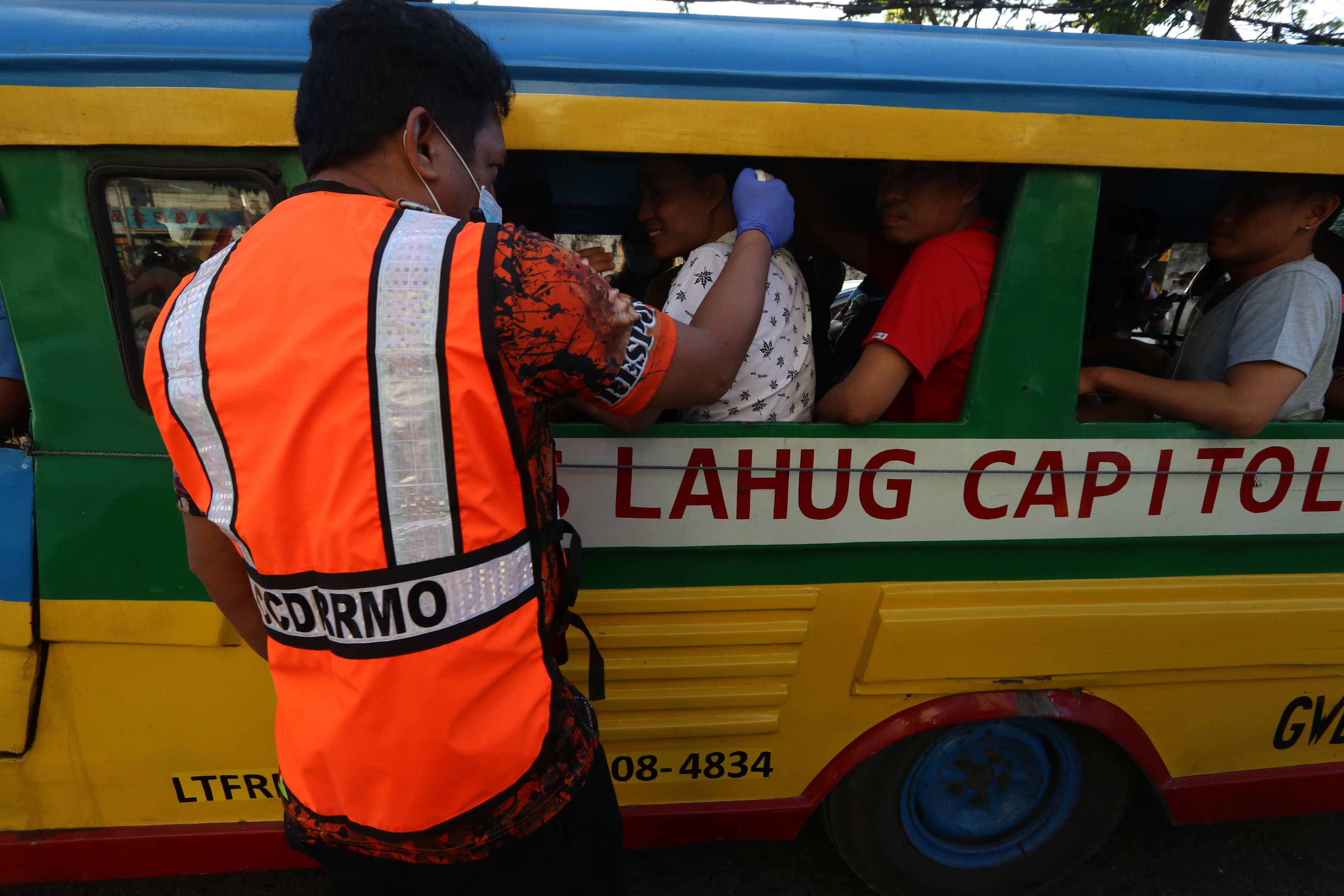 CHECKPOINT. Cebu City personnel check passengers' temperature in this March 2020 photo. File photo by Gelo Litonjua/Rappler  