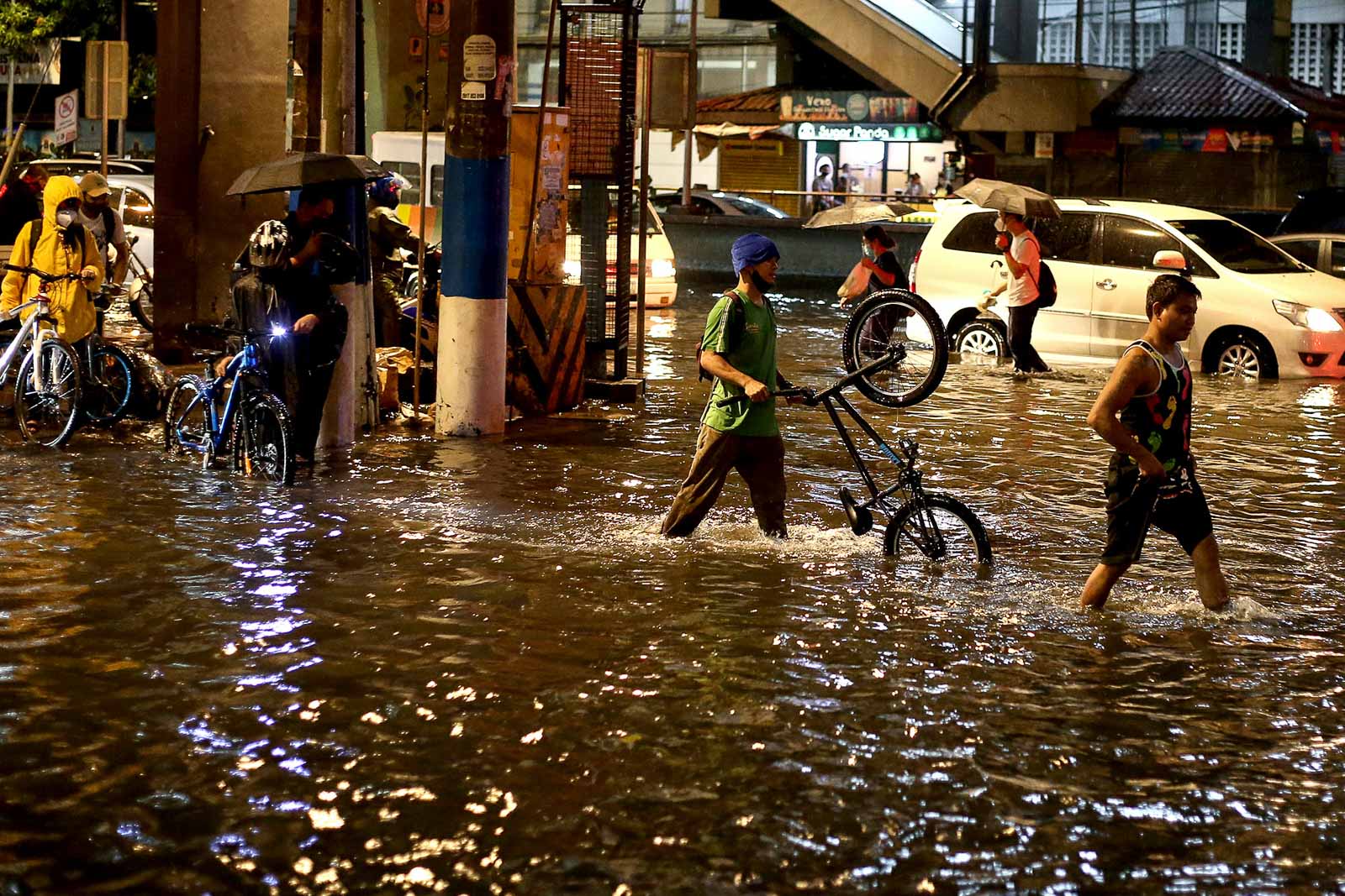 FLOODED. Bicycle riders and pedestrians wade through floods along Taft Avenue in Manila on June 11, 2020, after heavy rain from Tropical Depression Butchoy. Motorists are also stuck in traffic. Photo by Inoue Jaena/Rappler 