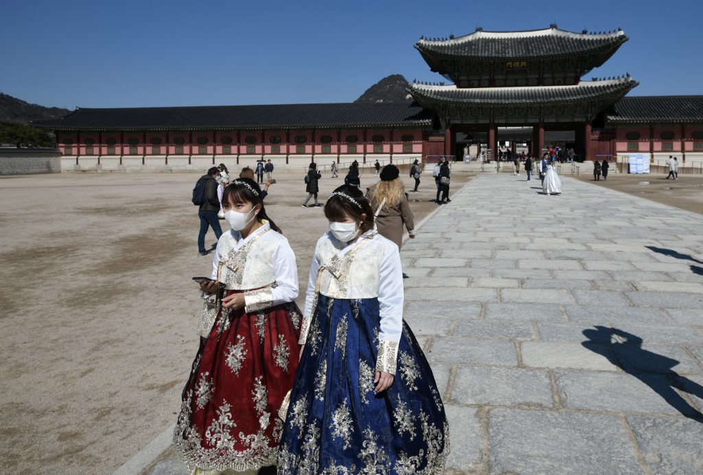 TOURIST DESTINATION. People in traditional Korean hanbok dresses wear face masks as they visit Gyeongbokgung Palace in Seoul, South Korea, on February 23, 2020. Photo by Jung Yeon-je/AFP 