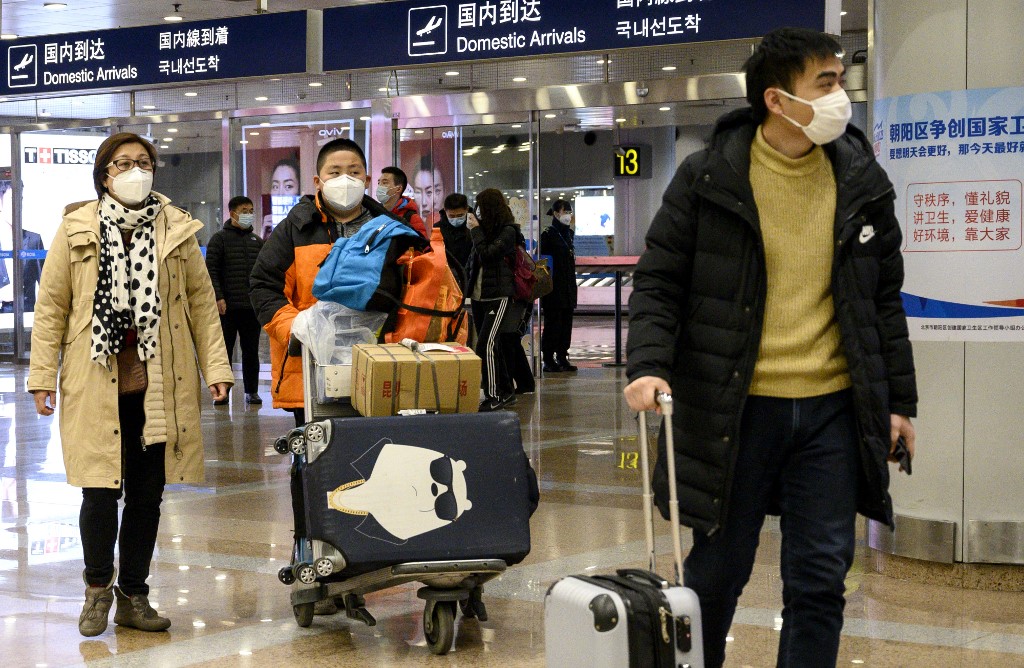TRAVEL LIMITS. Passengers, wearing protective face masks, walk at the arrival area of the Beijing Capital International Airport on January 31, 2020. File photo by Noel Celis/AFP  
