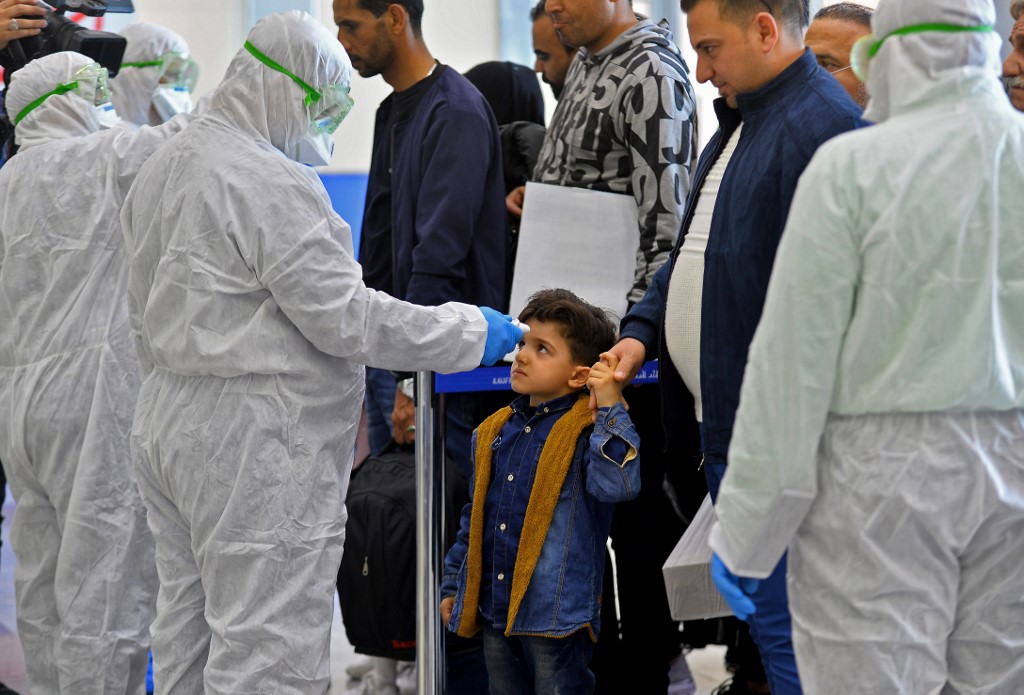 CHECK. The body temperature of an Iraqi child returning from Iran is measured upon her arrival at the Najaf International Airport on February 21, 2020. Photo by Haidar Hamdani/AFP 