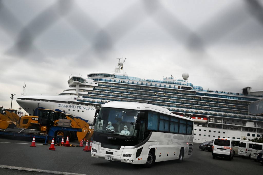 STILL IN JAPAN. File photo of a bus departing from the dockside next to the Diamond Princess cruise ship at the Daikoku Pier Cruise Terminal in Yokohama port on February 14, 2020. Photo by Charly Triballeau/AFP 