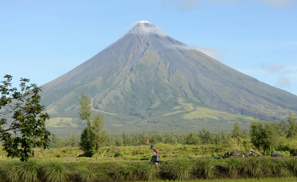 MAYON VOLCANO. A farmer walks along a rice field near the foot of Mayon Volcano in Albay on December 11, 2014. File photo by Ted Aljibe/AFP 