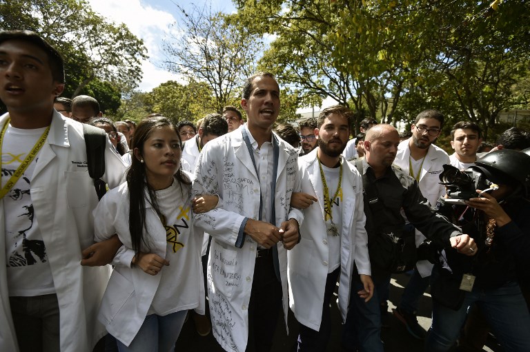 VENEZUELA PROTESTS. Opposition leader and self-proclaimed "acting president" Juan Guaido (C), chants slogans as he marches with students during a protest he convened against the government of President Nicolas Maduro, outside Venezuela's Central University (UCV) in Caracas, on January 30, 2019. Photo by Luis Robayo/AFP 