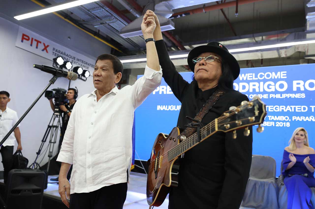 'VOTE FOR FREDDIE.' President Rodrigo Duterte raises the hand of singer Freddie Aguilar on the sidelines of the Parañaque Integrated Terminal Exchange (PITX) inauguration. Malacañang photo 