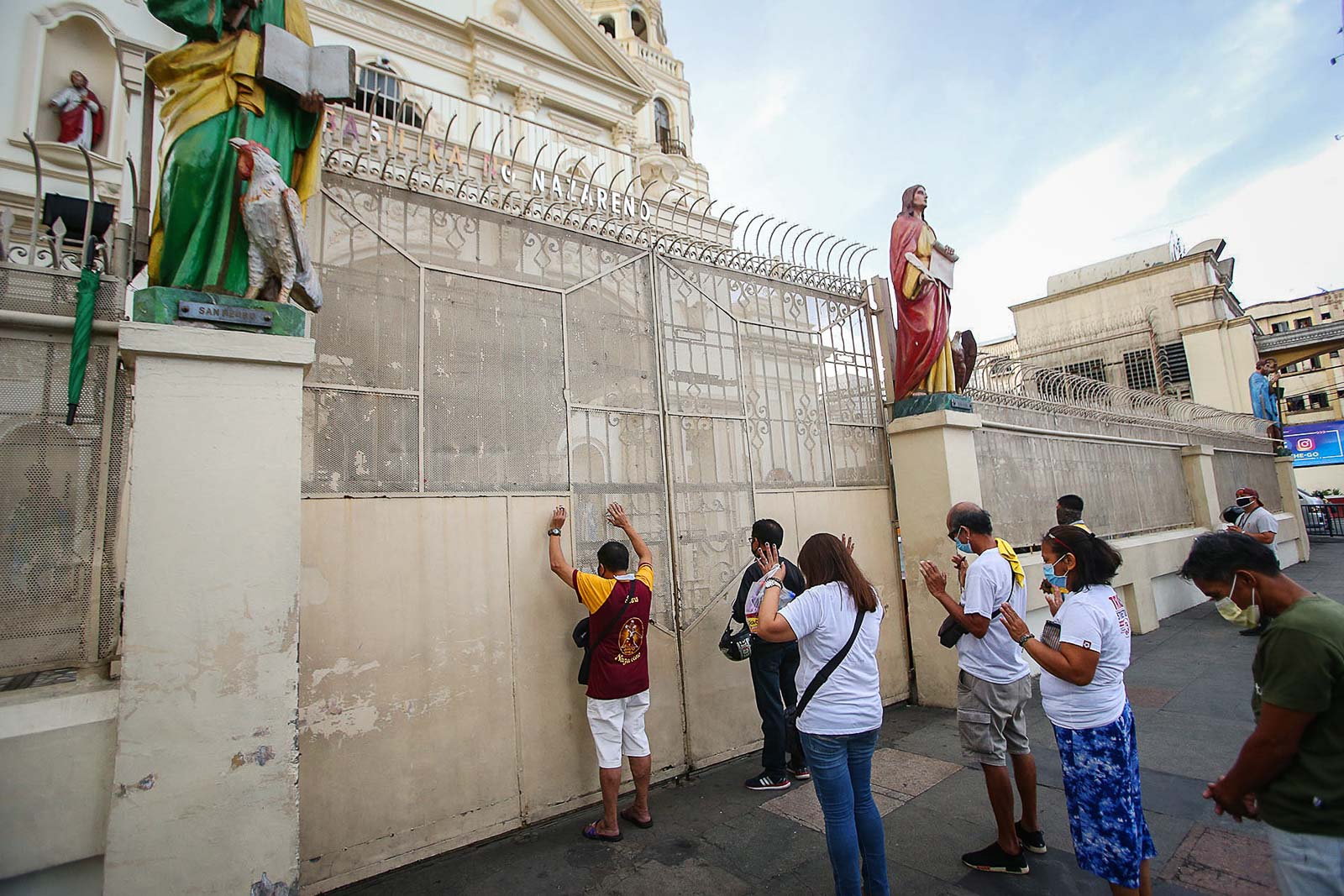 CLOSED. Catholic devotees pray in front of the closed gate of the Minor Basilica of the Black Nazarene in Manila on March 20, 2020. Photo by Inoue Jaena/Rappler 