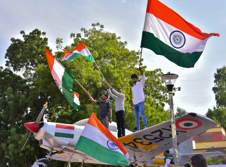 AIR STRIKE. Indian residents hold flags on a model of a military plane to celebrate the Indian Air Force (IAF) strike launched on a Jaish-e-Mohammad (JeM) camp at Balakot, in Bikaner in the Rajasthan state on February 26, 2019. Photo by Dinesh Gupta/AFP 